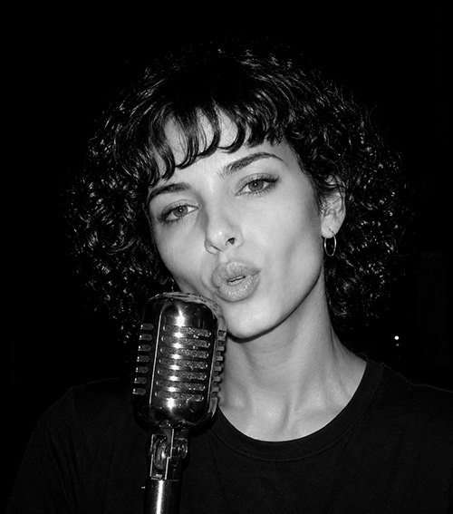 Valerie Luh cantando ante un micrófono vintage